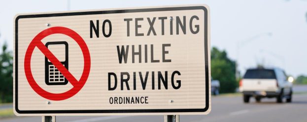 no texting while driving and a picture of a cell phone with a red line through it